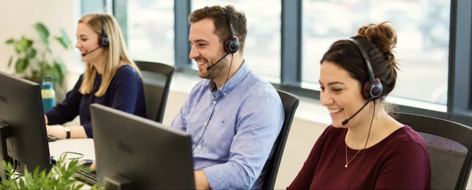The Ask Rose customer service team at their desks wearing headsets